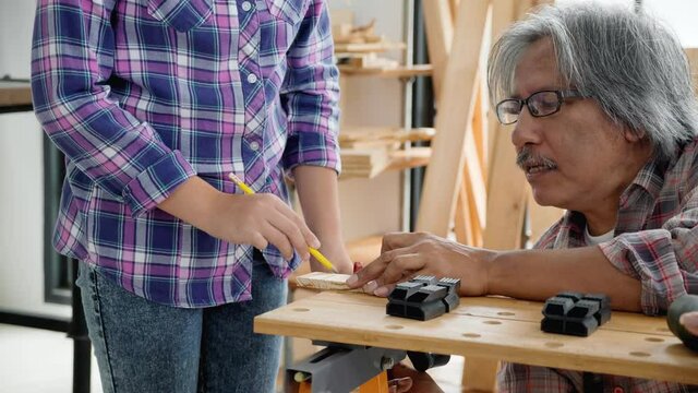 Asian family Father and daughter work in the home carpentry during the holiday. Home repair skill training activity During Work at home. Relationship Old young family. Concept Education And learn