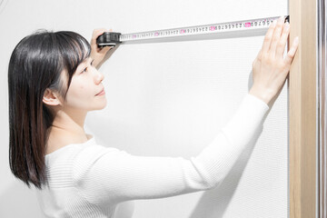Standing woman measuring with a tape measure