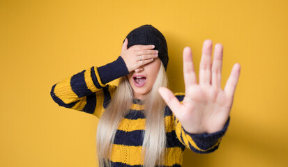 Don't come in any closer. Woman covering face and eyes with hand. Gesture with fear face...