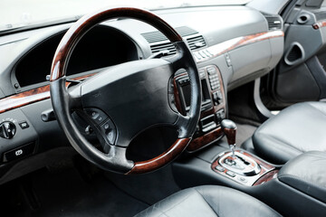 Modern car interior, black perforated veneered parts, aluminum, control parts, leather steering...