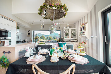 Nowoczesny dom z duæymi oknami, stół w kuchni udekorowany na Wielkanoc, duża przestrzeń
