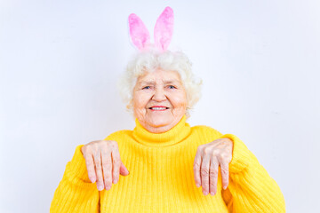 european senior pensioner with bunny ears in studio wall