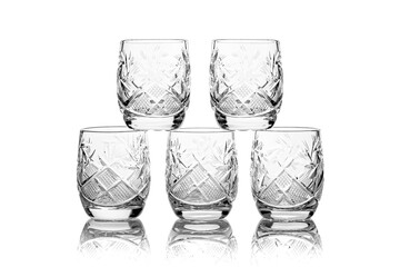 Five crystal empty glasses of vodka isolated on white background with reflection
