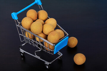 The longan is in the shopping cart, Longan is on the wooden table