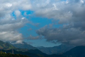 Communications antennas on top of a hill surrounded by mountains in the Colombian landscape.