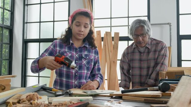 Asian family Father and daughter work in the home carpentry during the holiday. Home repair skill training activity During Work at home. Relationship Old young family. Concept Education And learn