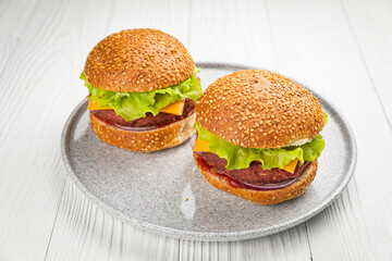 Fresh burger with vegan meat and vegetables, sprinkled with sesame seeds
