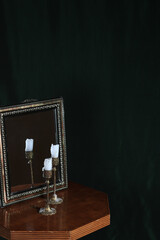 Mystic still life with mirror, reflection and two burning candles. Halloween concept
