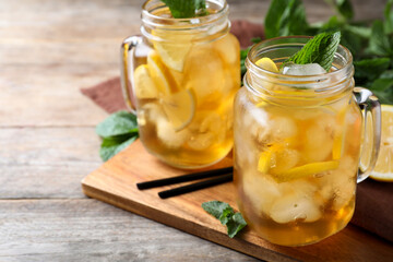 Delicious iced tea on wooden table, space for text