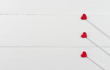 Three red hearts on white wooden background. Top view. Card for valentine's day or wedding with copy space.