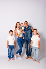 Fototapeta premium beautiful happy young family with three children in denim dress on white background