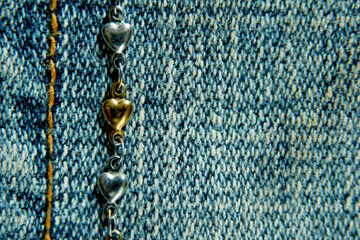 gold and silver heart necklace on jeans background