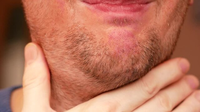 Close-up face of Caucasian man over 40, sad unshaven dissatisfied with his appearance. Tired man looks at himself and is very worried. the awakened unshaven man looks in the mirror. selective focus