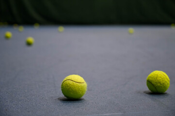 Close-up of tennis balls on blue hard court.