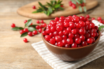Tasty ripe cranberries on wooden table, closeup