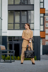 Lawyer Of Successful Business Woman Holding Cup Of Hot Drink In Hand On Her Way To Work On City Street. Caucasian businesswoman smiling happy outside.