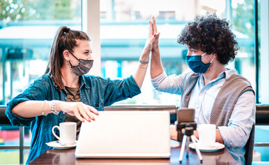 Young milenial influencers at coworking space with facemask - New normal marketing concept with...