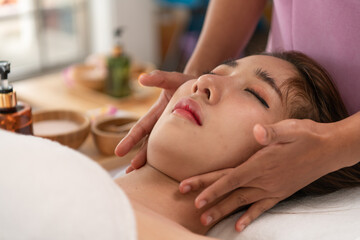 Obraz na płótnie Canvas Portrait of young beautiful asian woman enjoys massage in a luxury spa resort