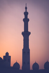 The standalone minaret of the Sheikh Zayed Grand Mosque in Emirates, Abu Dhabi at dusk. Holy place for the muslims and Muslims go there to pray and worship.