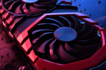 Computer game graphics card, videocard with two coolers on circuit board ,motherboard background. Close-up. With red-blue lighting