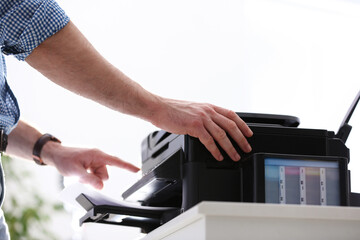 Employee using modern printer in office, closeup