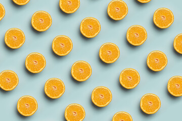 Colorful fruit pattern of fresh orange slices on blue background. Top view oranges.