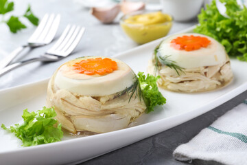 Delicious chicken aspic with eggs and vegetables on plate, closeup