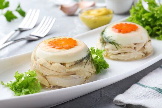 Delicious chicken aspic with eggs and vegetables on plate, closeup