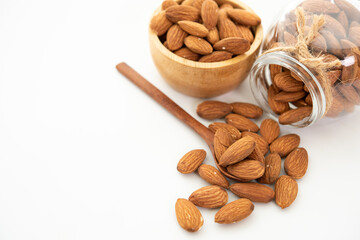 almond in a wooden spoon and bowl. Glass jar with almond on white background. (selective focus;...
