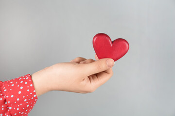 Obraz premium Woman holding red heart on grey background, closeup. Happy Valentine's Day