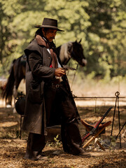 A senior cowboy standing with a gun to guard the safety of the camp in the western area