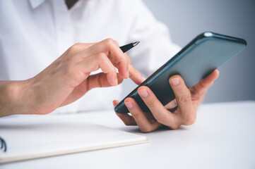 Close up of women's hand using cellphone or mobile for search website,data,social network with comunication.Business and finance concept.