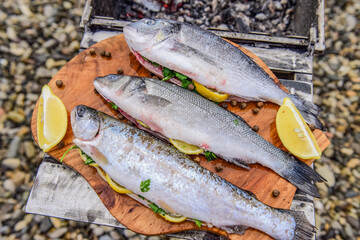 raw fish stuffed with lemon and herbs on the background of the sea