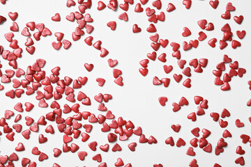 Bright heart shaped sprinkles on white background, flat lay