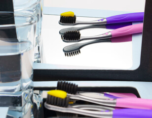 Children's toothbrushes, with toothpaste and reflection in the mirror.