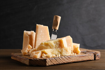 Fototapeta premium Parmesan cheese with board and knife on wooden table