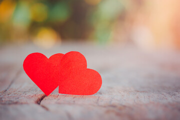 Fototapeta premium Close-up couple red heart on wood table to show status of love on Valentine's Day, Day of love, copy space, romantic concept for important day or marriage day on bokeh background.