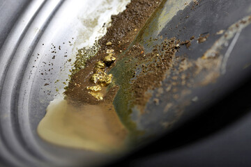 gold nuggets in a metal gold pan