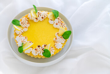 Lemon Tart citrus cake in white dish and white cloth background,