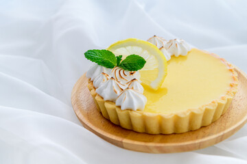 Lemon Tart citrus cake in wood dish and white cloth background,