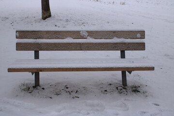 Sitzbank die im Winter mit Schnee bedeckt ist