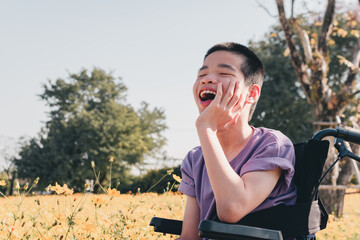 Fototapeta premium Disabled child on wheelchair is playing, learning and exercise in the outdoor like other people with parent,Forest background,Lifestyle of special child in education age, Happy disability kid concept.