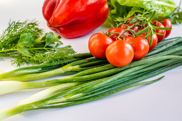 fresh vegetables on a white table. Such as cherry tomatoes, onions, peppers.