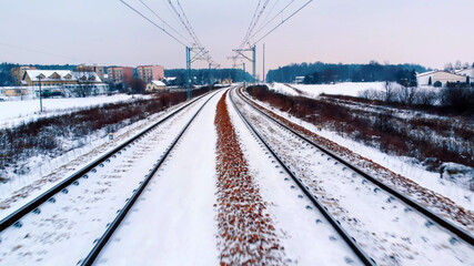 Point of view from the train on the railway covered with snow. Cold weather and winter transport. High quality photo