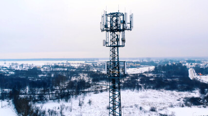 Drone orbiting around 5G antenna covered in snow. . High quality photo