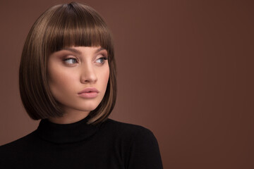 Portrait of a beautiful brown-haired woman with a short haircut on a brown background - 408101400