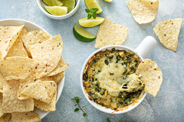 Artichoke spinach dip in a baking dish with a cheese pull