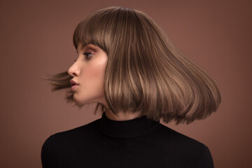 Portrait of a beautiful brown-haired woman with a short haircut on a brown background - 408101496