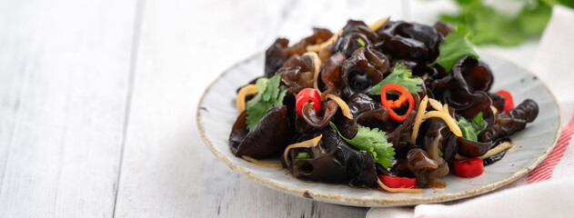 Boiled small black fungus cold dish on white table background. © YamisHandmade