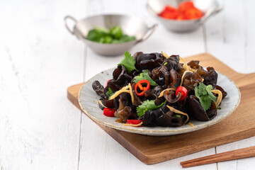 Boiled small black fungus cold dish on white table background.
